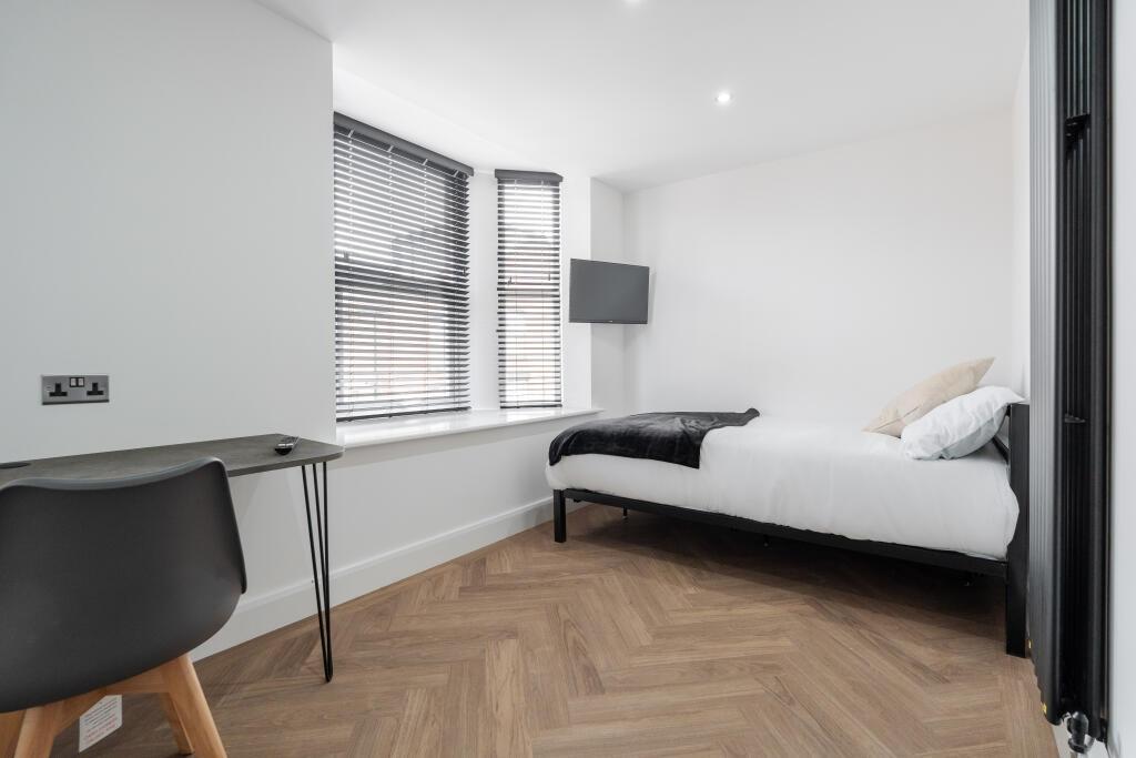A spacious and bright master bedroom featuring ...