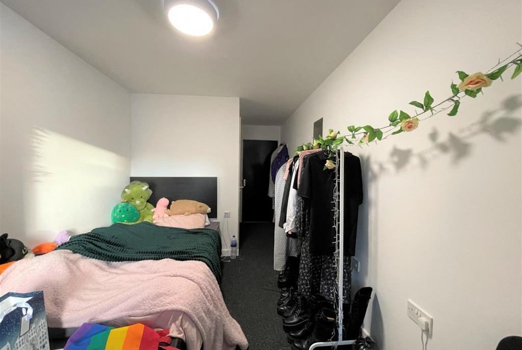 Bright, simply furnished bedroom with a comfort...