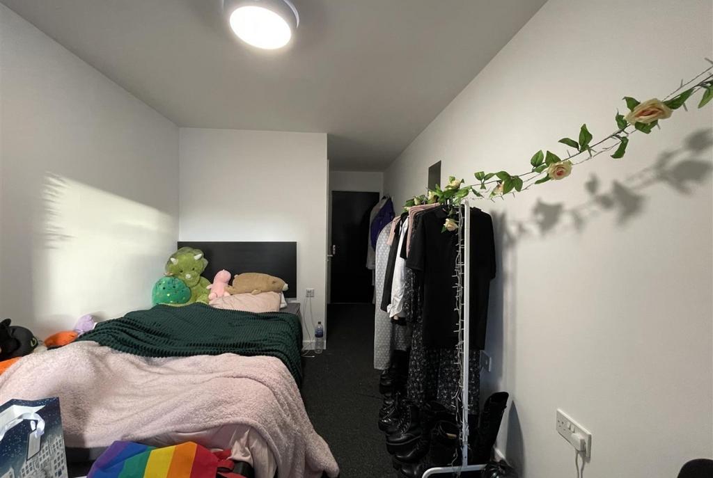 Neat single bedroom with a comfortable bed, sof...
