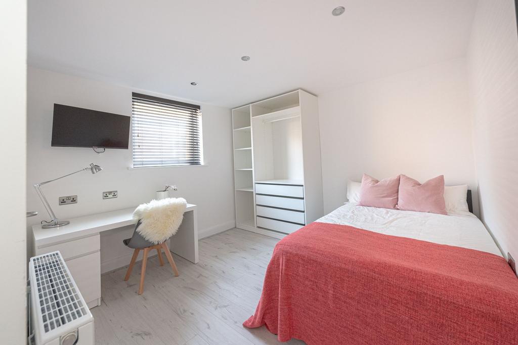Bright and airy bedroom with a comfortable doub...