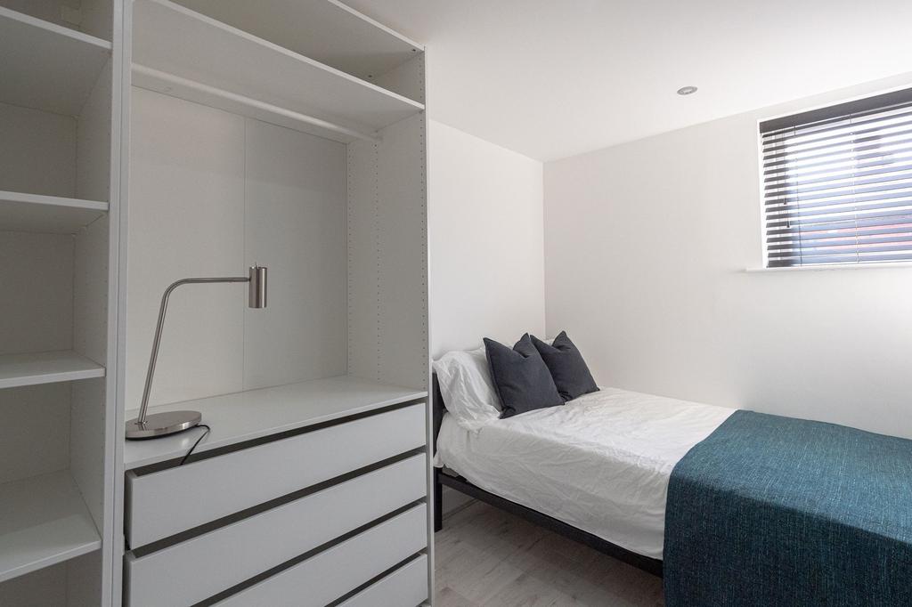 A minimalistic, well-maintained bedroom featuri...