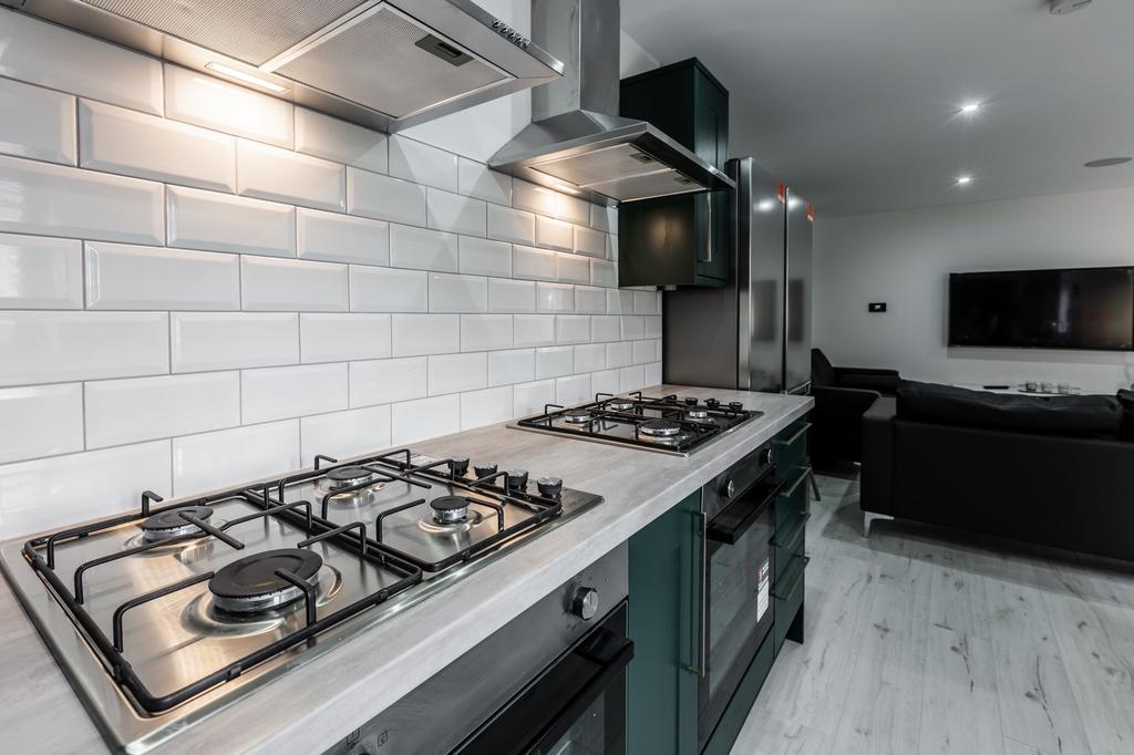 Modern kitchen with sleek white subway tile bac...