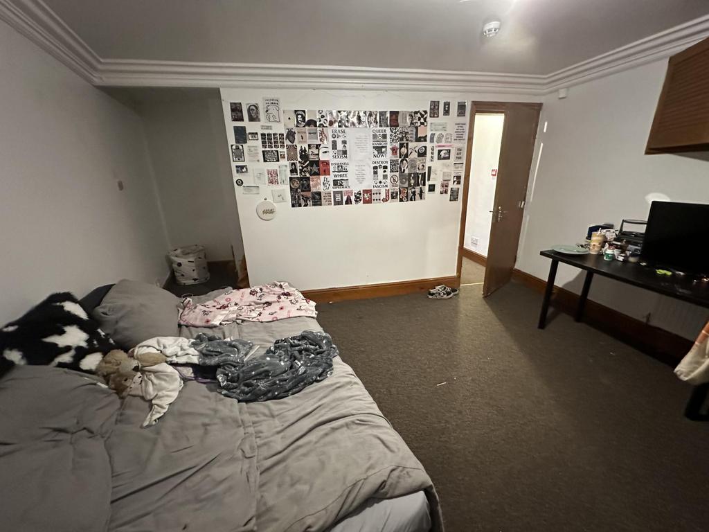 A well-lit double bedroom featuring a large bed...
