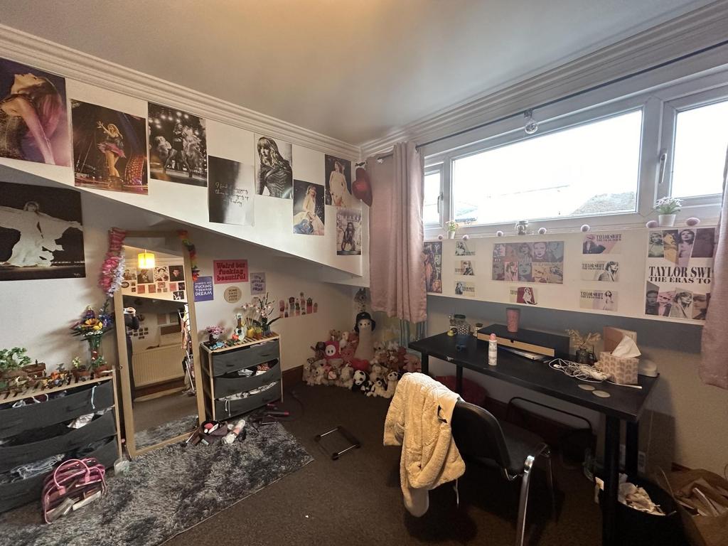 A cozy bedroom featuring a desk and chair, deco...