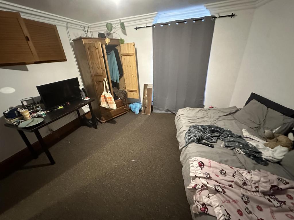 A modest bedroom featuring a double bed with so...