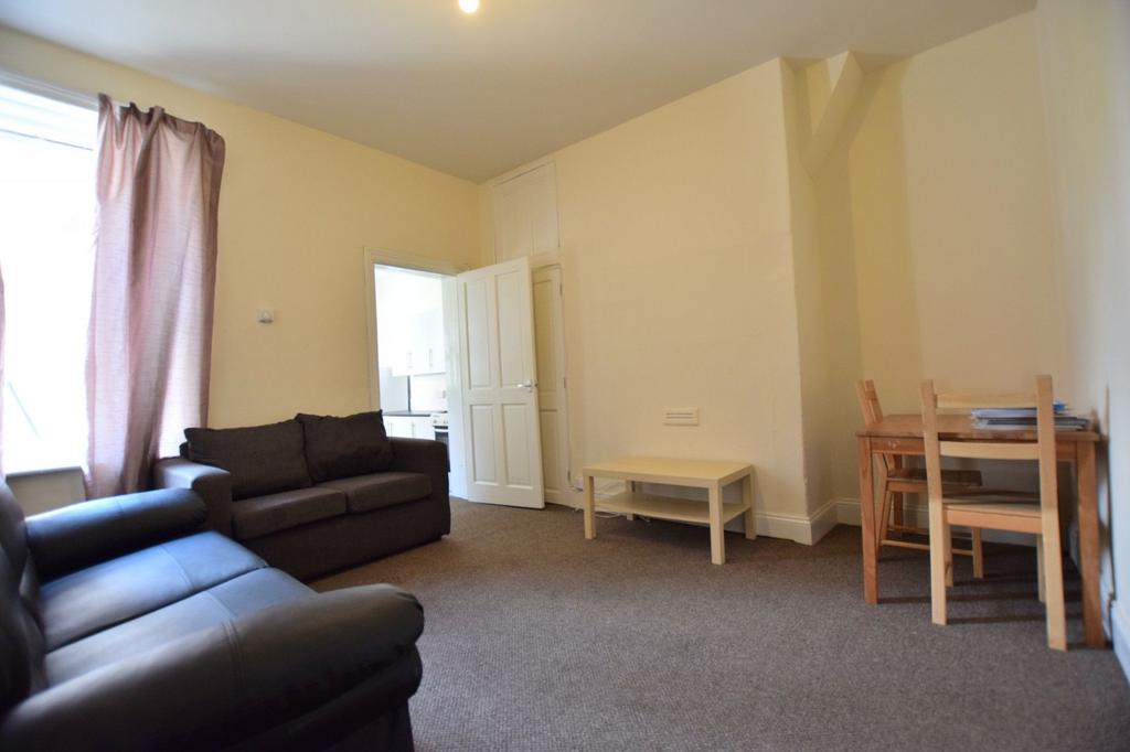 Bright, simply furnished living room with two c...