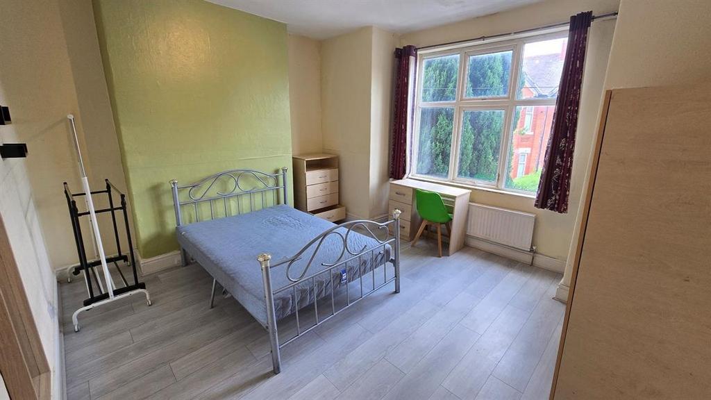 Bright double bedroom with a metal-frame bed, l...