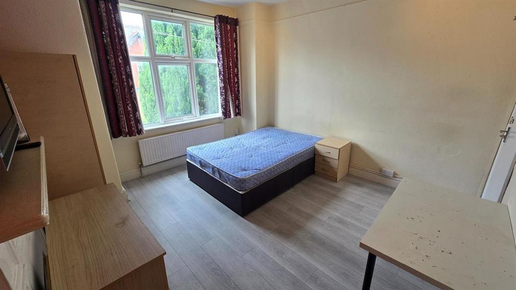 Bright, simply furnished bedroom with a large w...