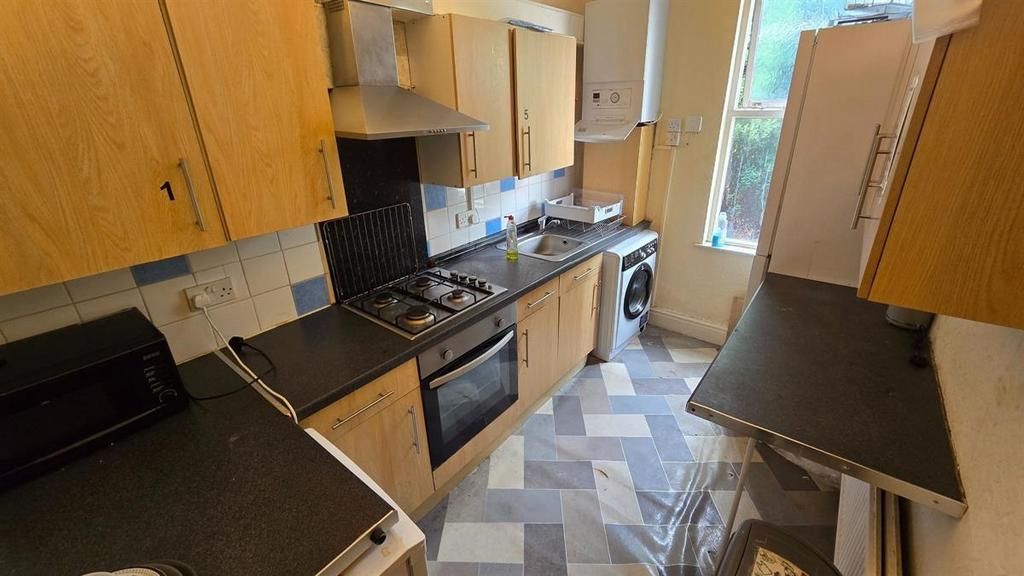 Bright galley kitchen with fitted cabinets, int...