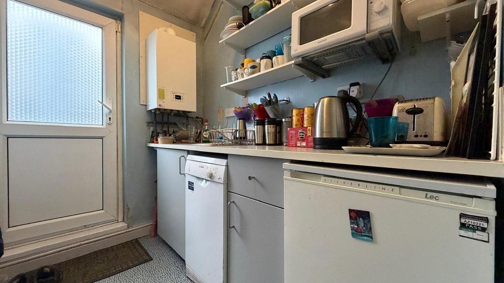 Neat galley-style kitchen with white appliances...