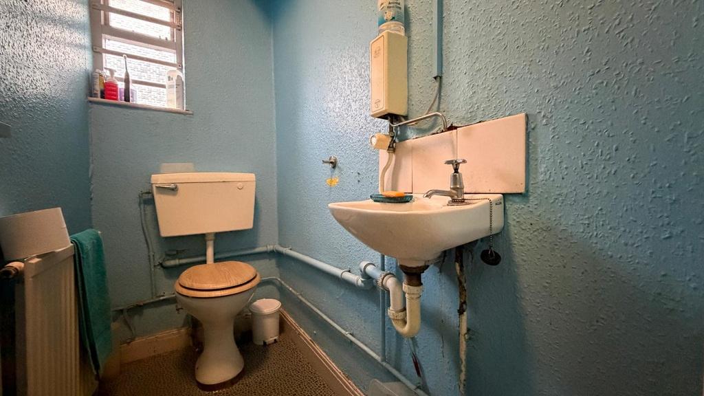 Compact bathroom with a toilet and wall-mounted...