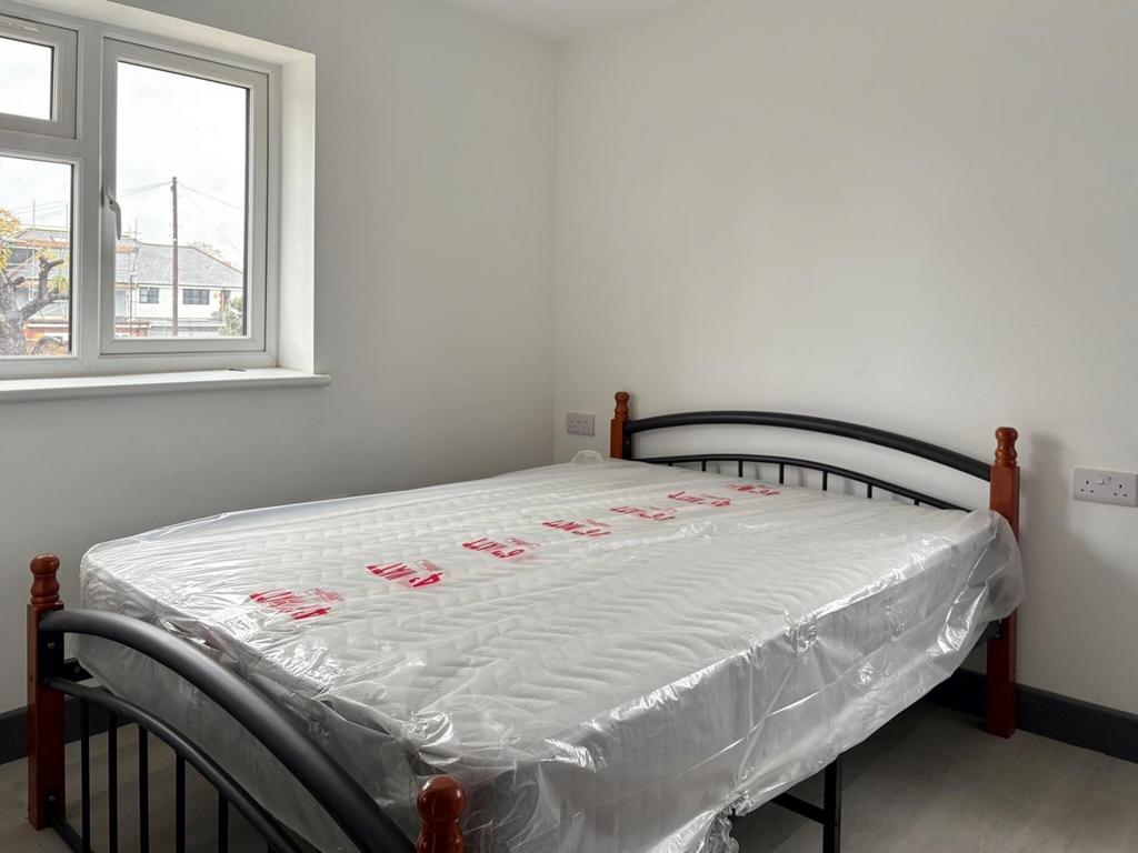 Bright, simply furnished bedroom with a metal-f...