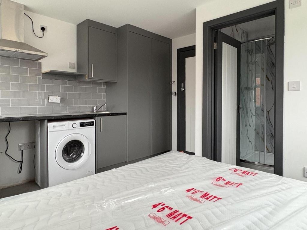 Bright, modern studio bedroom with integrated k...
