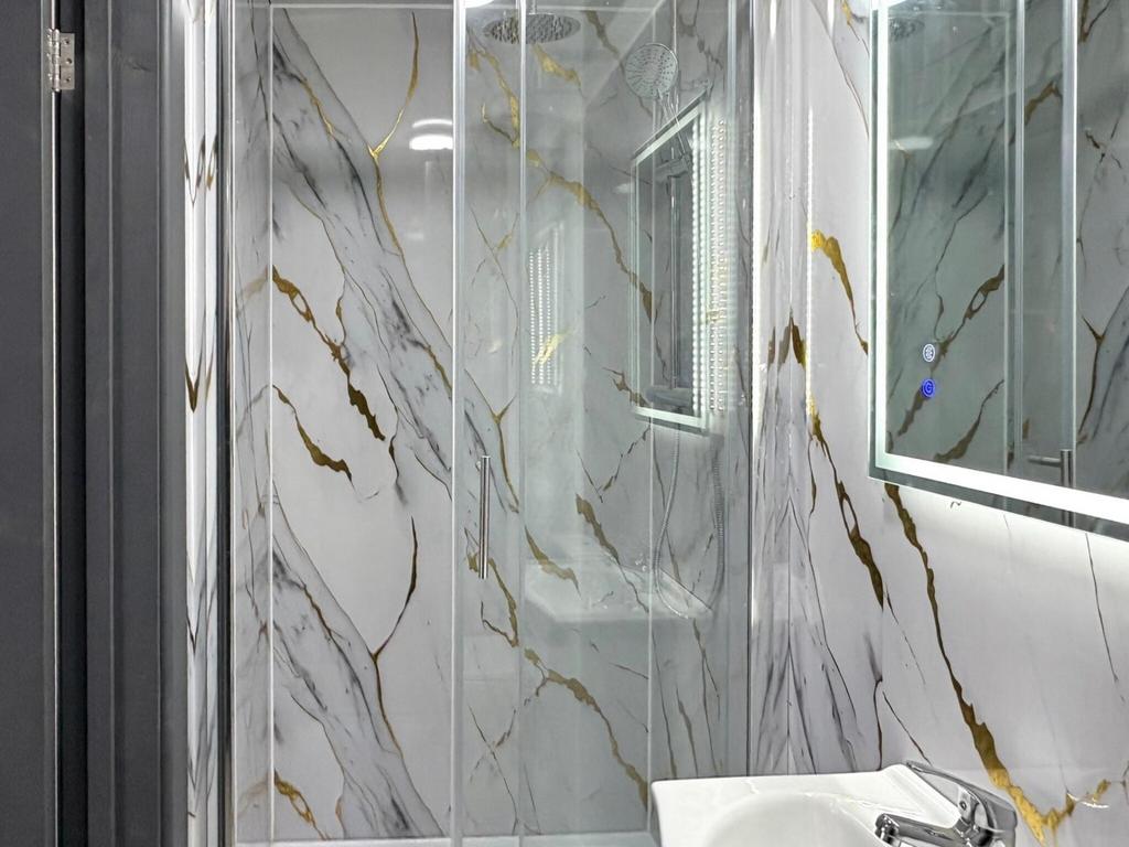 Contemporary bathroom suite featuring a glass-e...