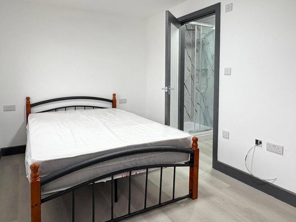 Bright, simply furnished bedroom with a double ...