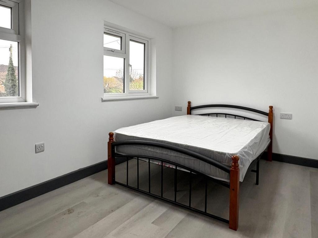 Bright, simply styled bedroom with a double bed...