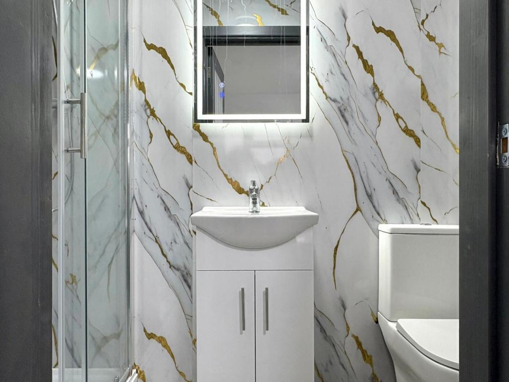 Contemporary bathroom with marble-effect walls,...