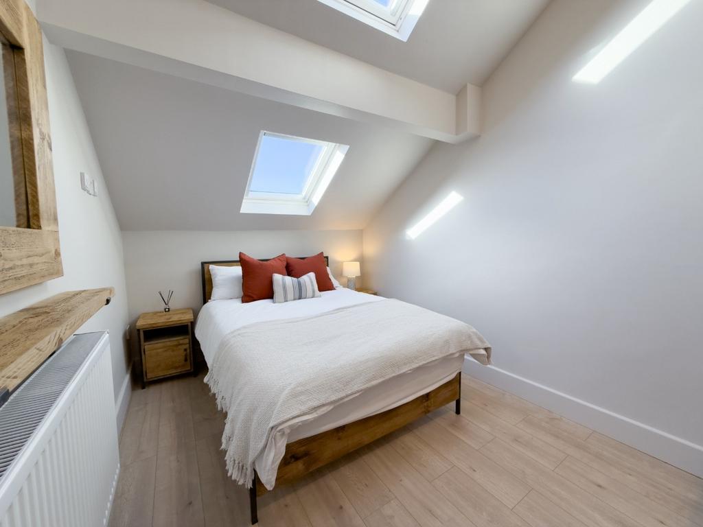Bright, modern attic double bedroom with skylig...