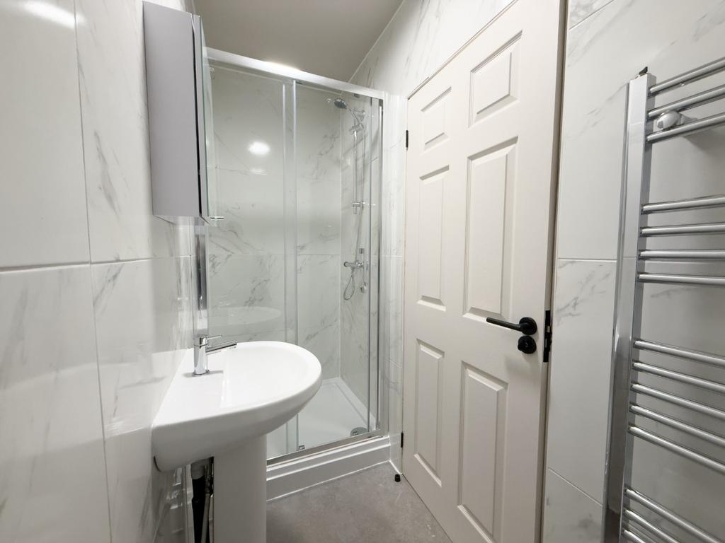 Bright, modern bathroom with a glass shower enc...