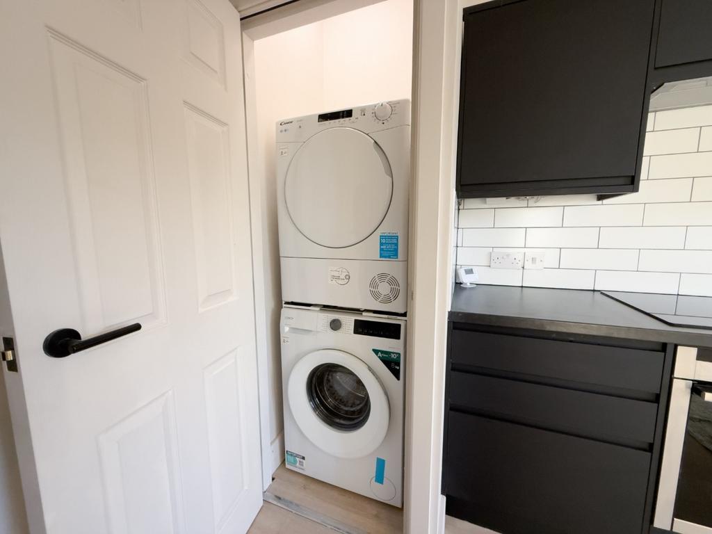Compact modern kitchenette with integrated stac...
