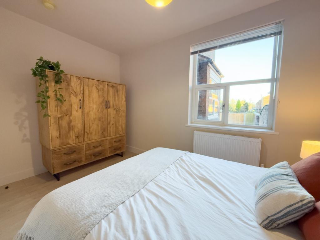 Bright, simply styled bedroom with a comfortabl...