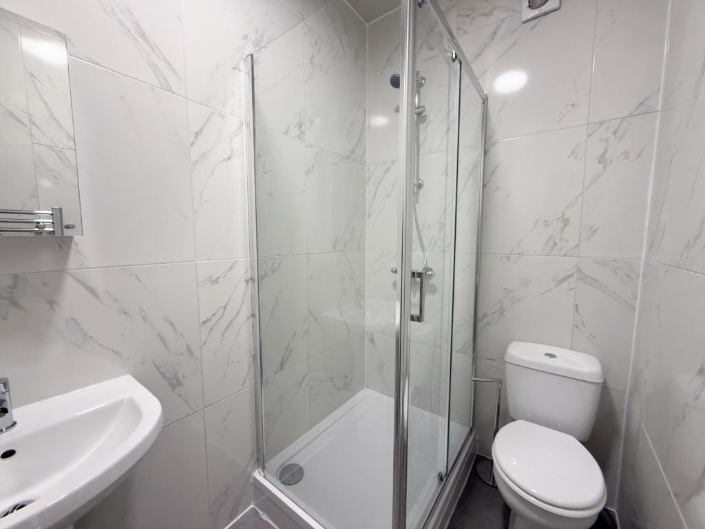 Modern bathroom with a corner glass shower encl...