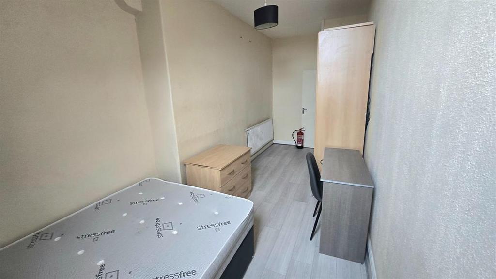 Bright, simply furnished bedroom with a single ...