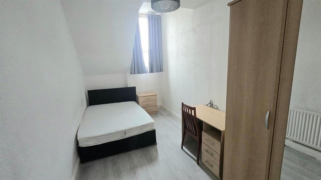 Neat single bedroom with a comfortable bed, des...