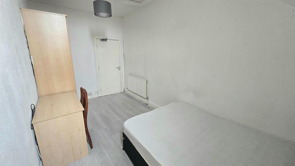 Bright, simply furnished bedroom with a single ...