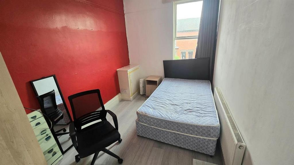 Neat, simply furnished bedroom with a comfortab...