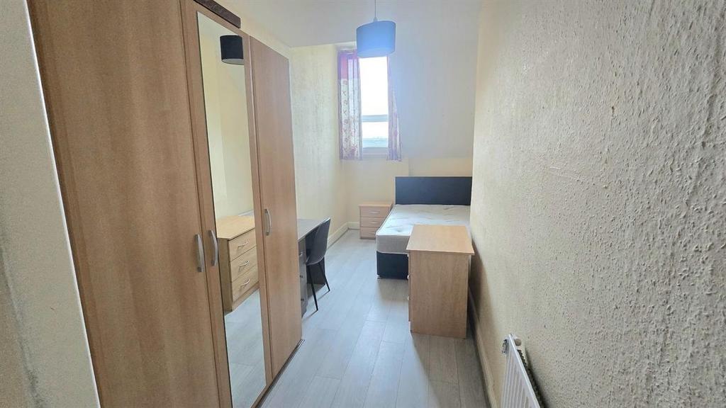 Bright, simply furnished bedroom with a window ...