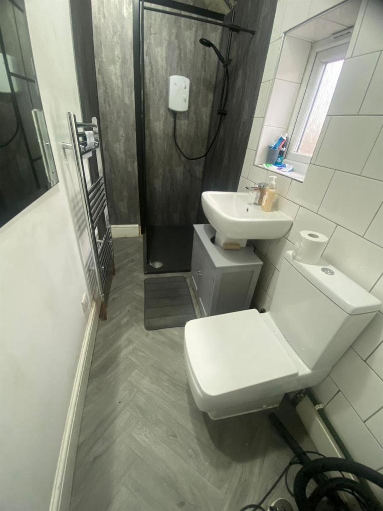 Modern bathroom with tiled walls, a walk-in sho...