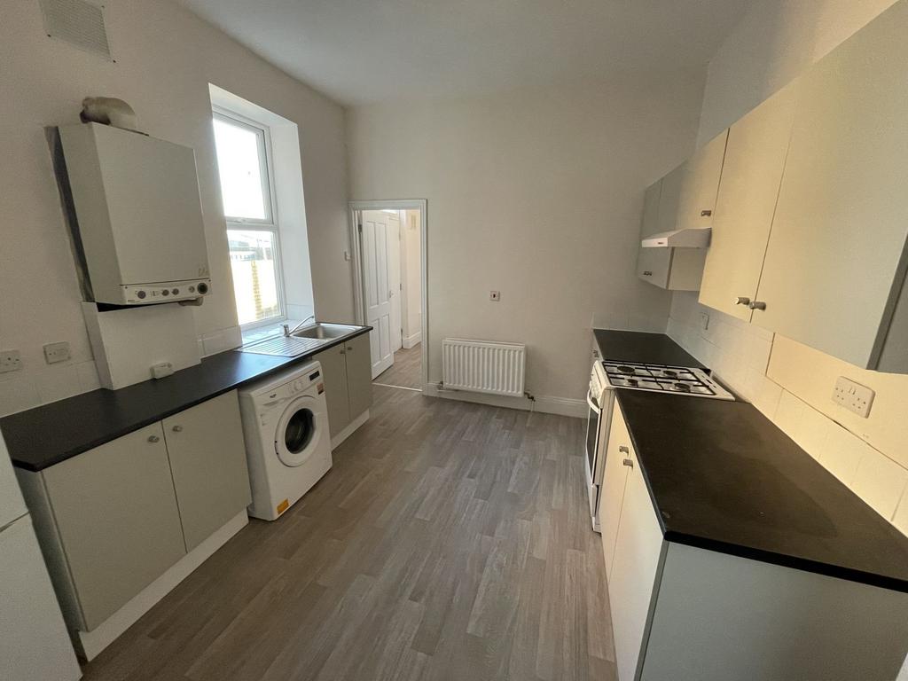 Bright galley kitchen with long worktops either...