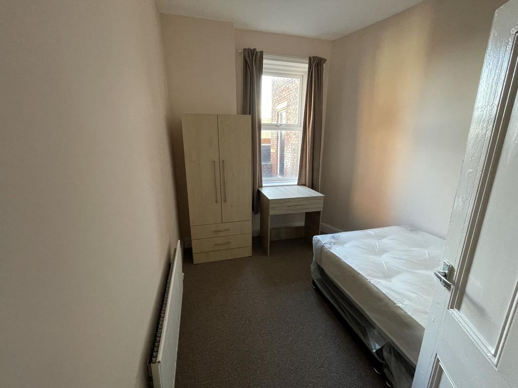 Bright, simply furnished single bedroom with a ...