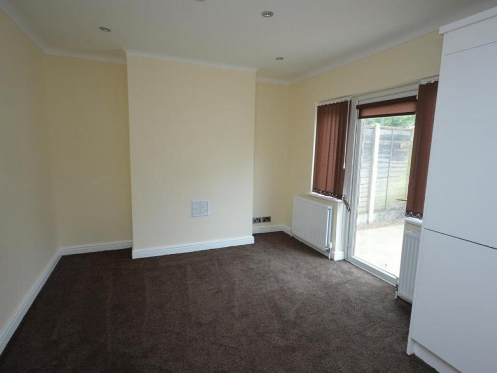 A bright and tidy living room featuring neutral...
