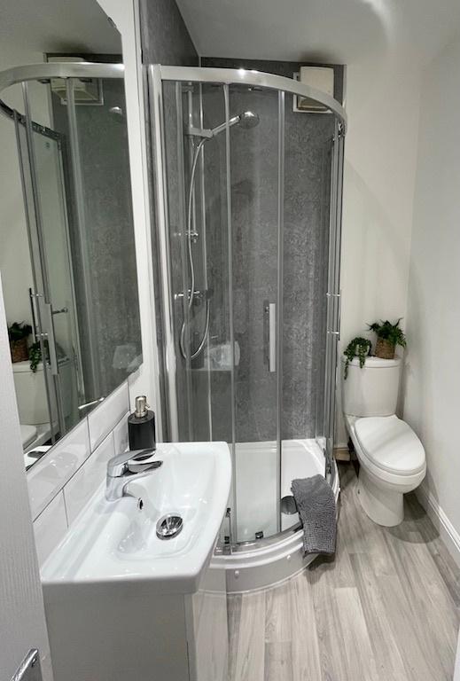 Modern, well-kept bathroom featuring a curved g...