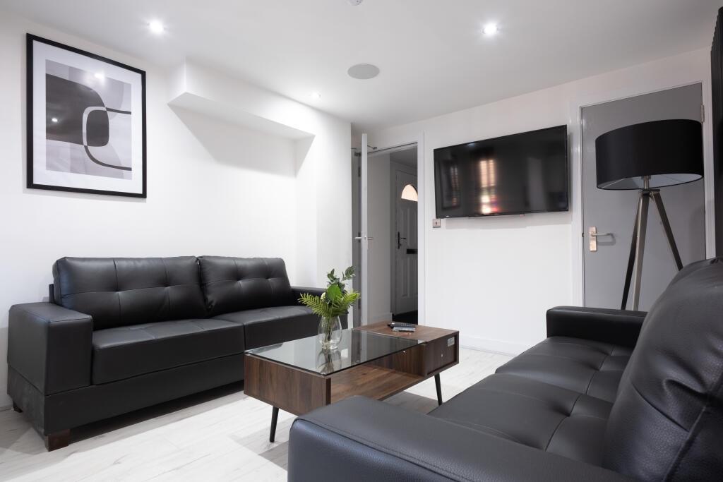 A modern living room featuring sleek black leat...