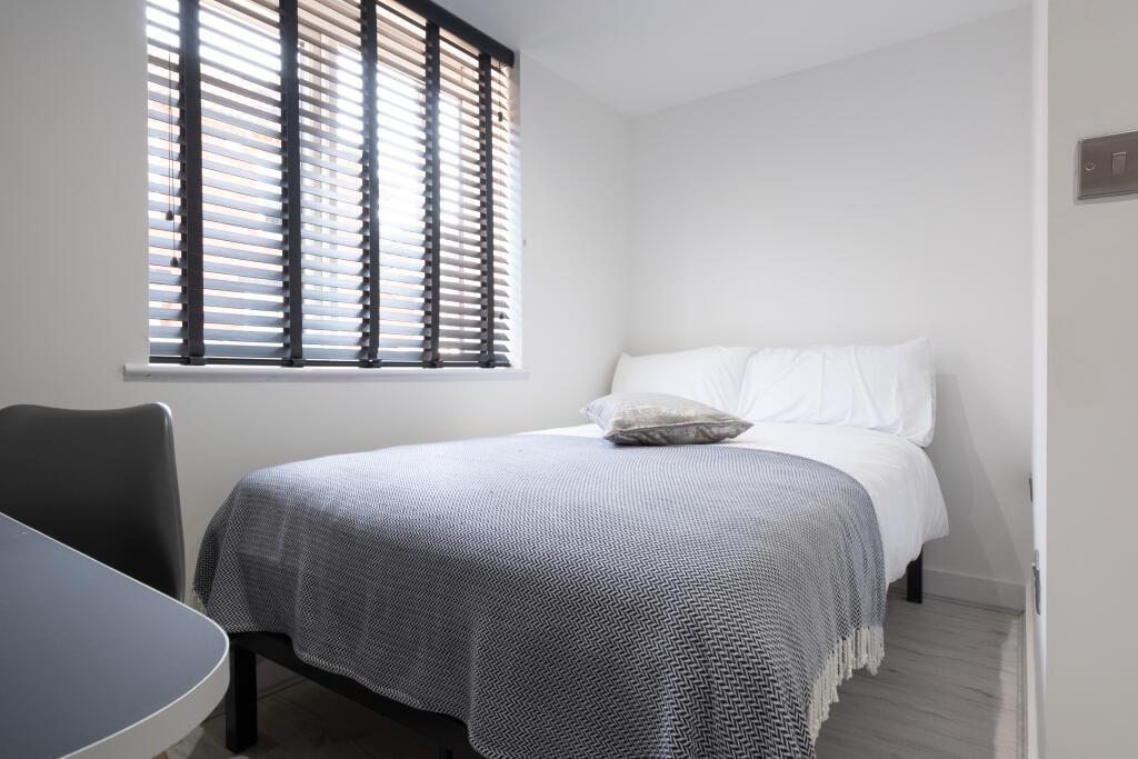 A bright and tidy single bedroom featuring a co...