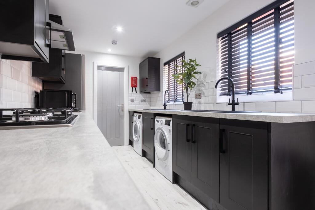 A sleek, modern kitchen featuring black cabinet...