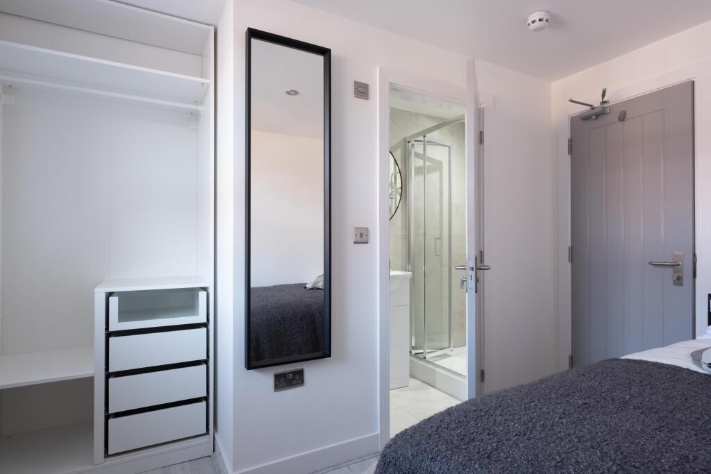 A modern double bedroom featuring a neatly made...