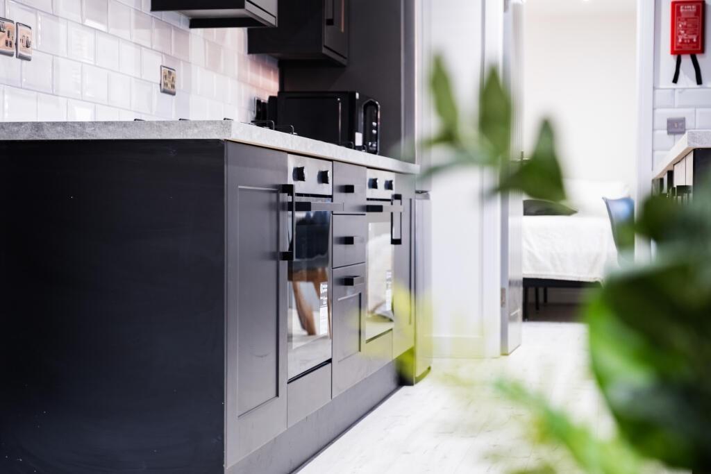 A modern kitchen with sleek black cabinetry and...