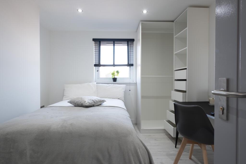 A bright and tidy single bedroom featuring a ne...