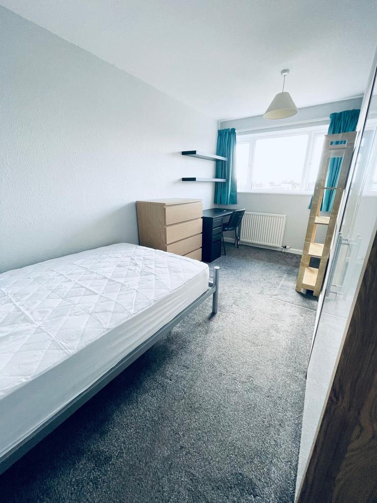 Bright, neatly furnished single bedroom with a ...