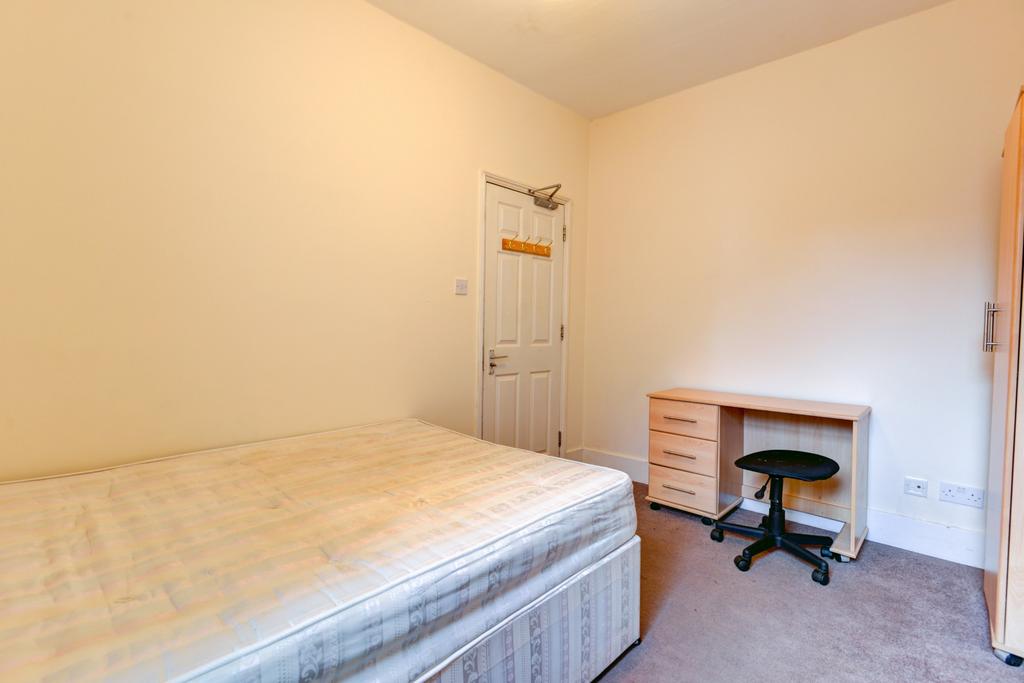 A cozy bedroom featuring a double bed and a sma...