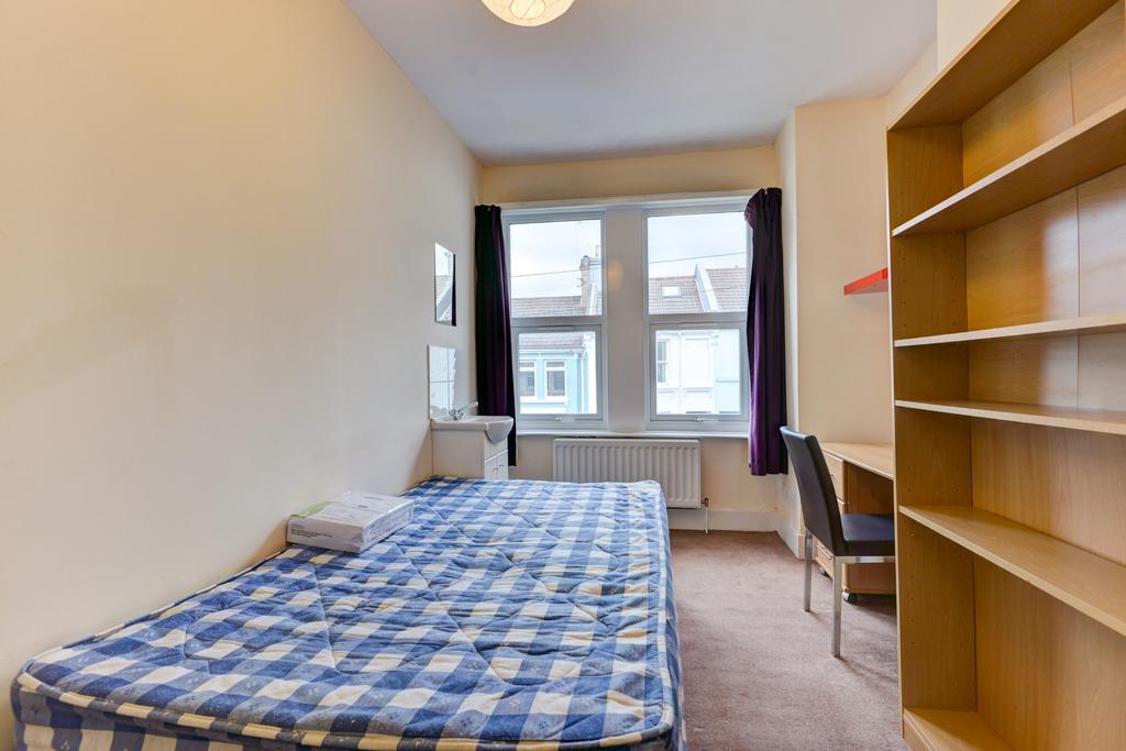 Bright and airy bedroom with a large window all...