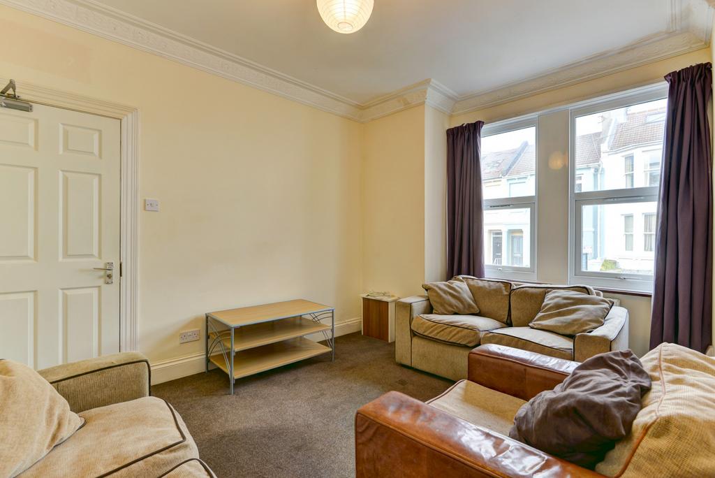 A spacious, well-lit living room featuring comf...