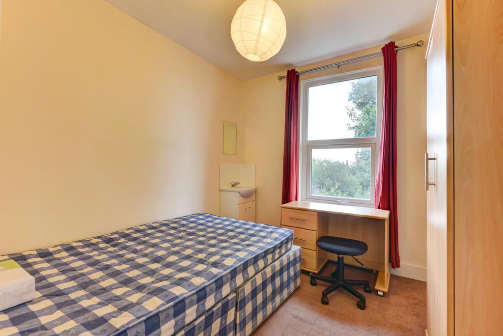 A cozy bedroom featuring a double bed with a ch...