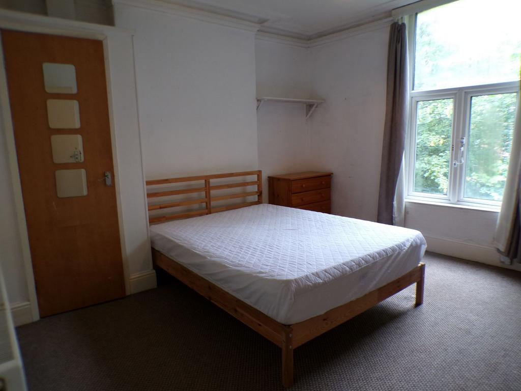 Bright double bedroom with a large window letti...