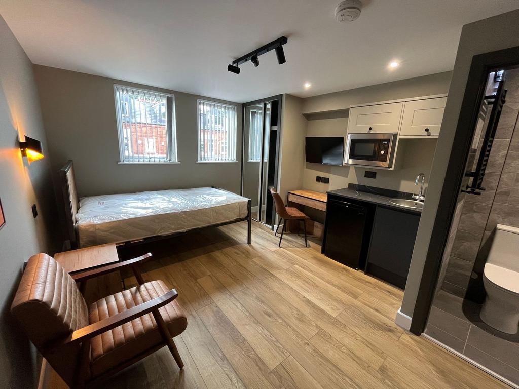 Bright, modern studio-style room with a comfort...