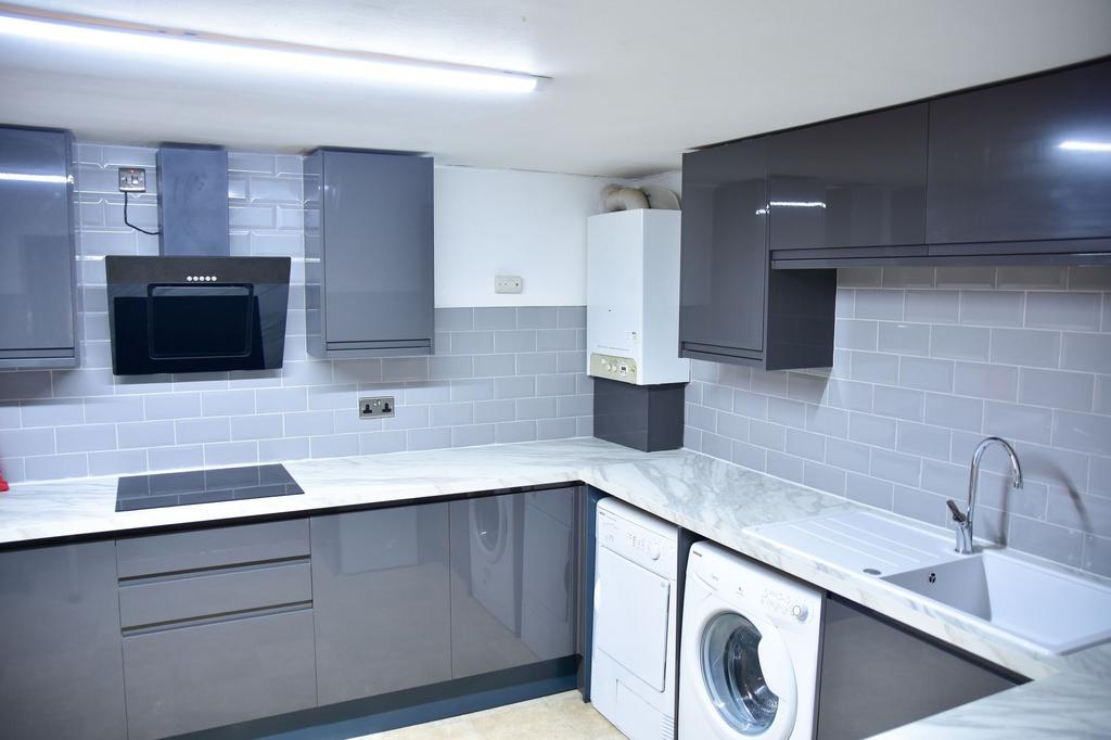 Modern and sleek kitchen featuring grey cabinet...